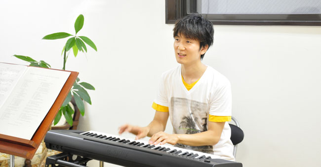 レッスン中の加藤慶之。キーボードを弾きながら歌っている様子